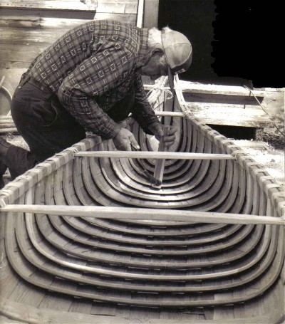 Jocko Carle pounding the ribs into the hull of a new birchbark canoe. Eastern birchbark canoes are reinforced with a complete system of ribs and planking ; some western Canadian and Alaskan birchbark canoes were built with a light rib and batten construction , not unlike the Eskimo kayak ; from ''Building an Algonquin Birchbark Canoe '' ; photo Henri Vaillancourt ; Maniwaki Quebec 1980.