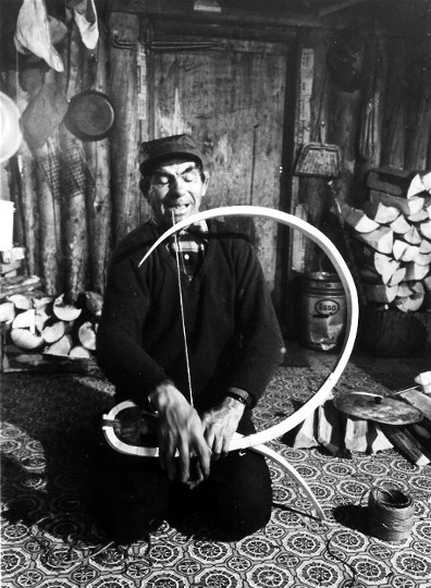 Philip Bosum of Mistassini,Quebec bending a beavertail snowshoe frame at his winter hunting camp on Assinica Lake; photo Henri Vaillancourt 1980