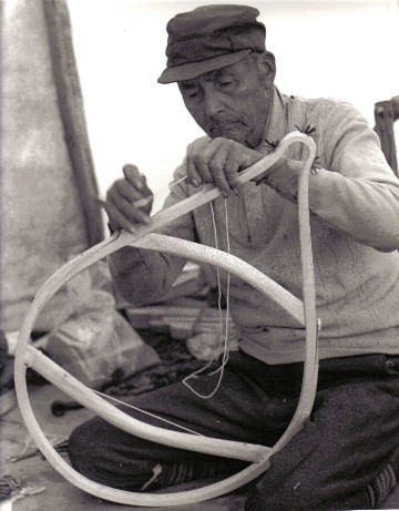Installing the selvage cord prior to weaving a pair of Montagnais beavertail snowshoes . Although women usually do the weaving , the men are responsible for  making the frames  and installing the selvage cords. This division of labor was seen among the Cree , Montagnais and Attikamek of Quebec,  and is common throughout much of the North . La Romaine , Quebec, 1978 ; photo Henri Vaillancourt