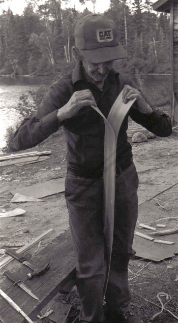  Basil splitting cedar for the planking of a birchbark canoe . Birchbark canoes often have planking a mere 1/16 '' in thickness ; from  ''Building an Algonquin Birchbark Canoe '' ; photo Henri Vaillancourt ; Maniwaki Quebec 1980